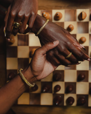 Two hands holding each other against a checkered background