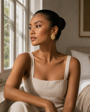 Model wearing Umutoni Asani gold earrings with elevated everyday styling.