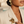 Load image into Gallery viewer, Female model wearing the gold Umutoni Malkia brooch and earrings, handmade in Kenya.

