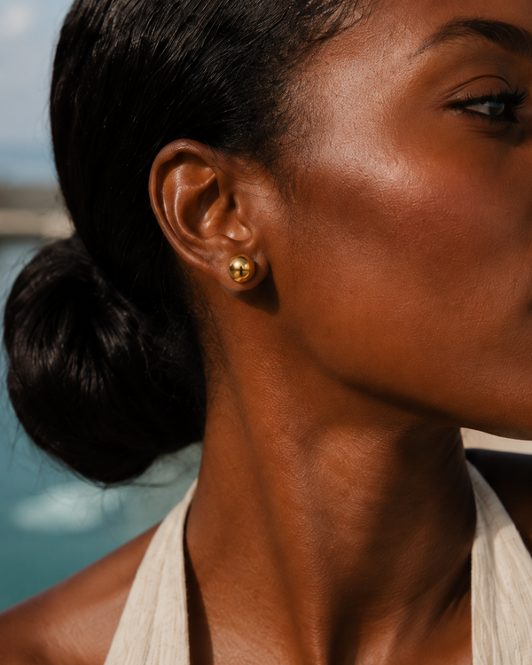 Model wearing Umutoni Nalla gold earrings, handmade in Kenya.